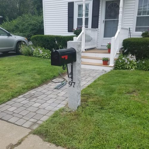 a front of a house with a walkway and a mailbox