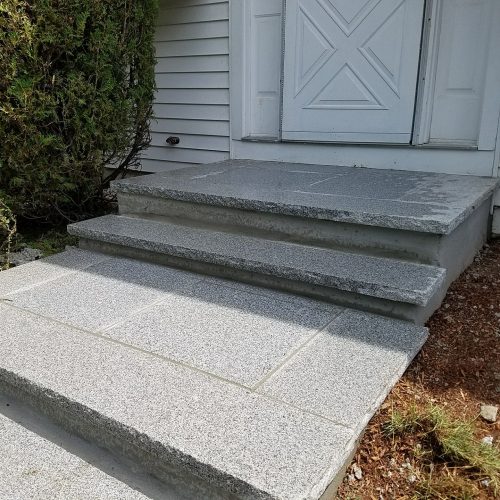 Granite steps leading to a white door.